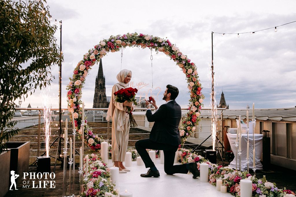 Flower Magic marriage proposal in Cologne – flower arch at cathedral, man kneeling with ring