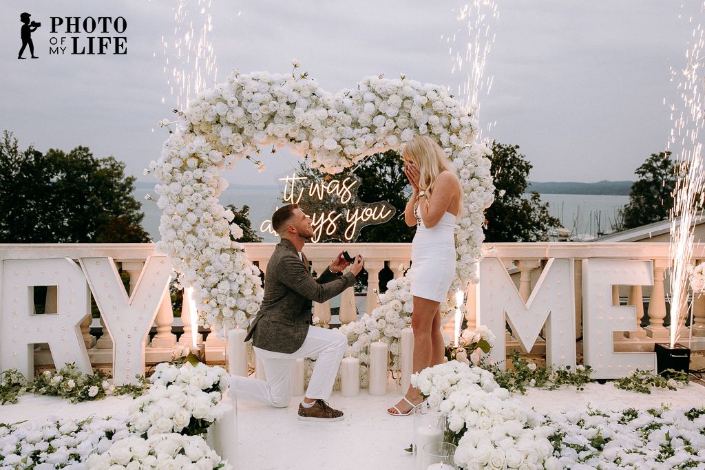 Heaven on Earth proposal – white flower heart with fireworks and man kneeling