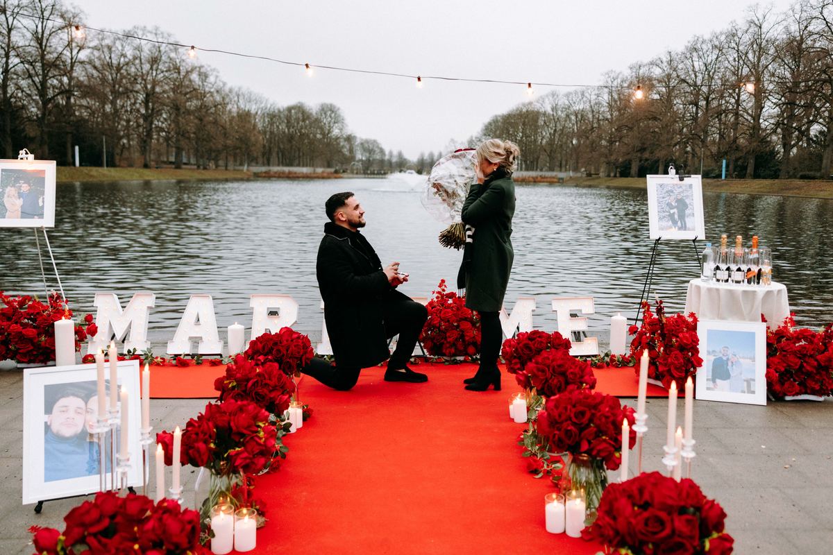 Marriage proposal at romantic lake – red roses with MARRY ME letter arrangement