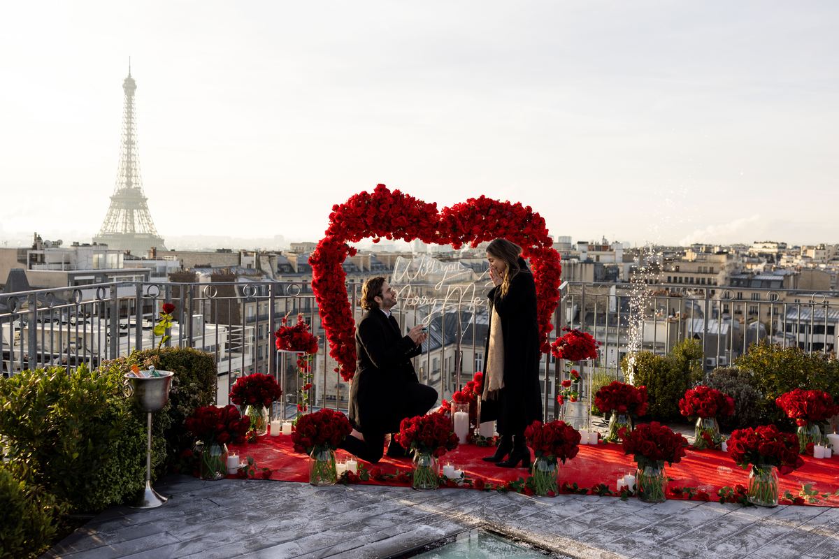 Winter marriage proposal in Paris – red heart on rooftop with Eiffel Tower in snow