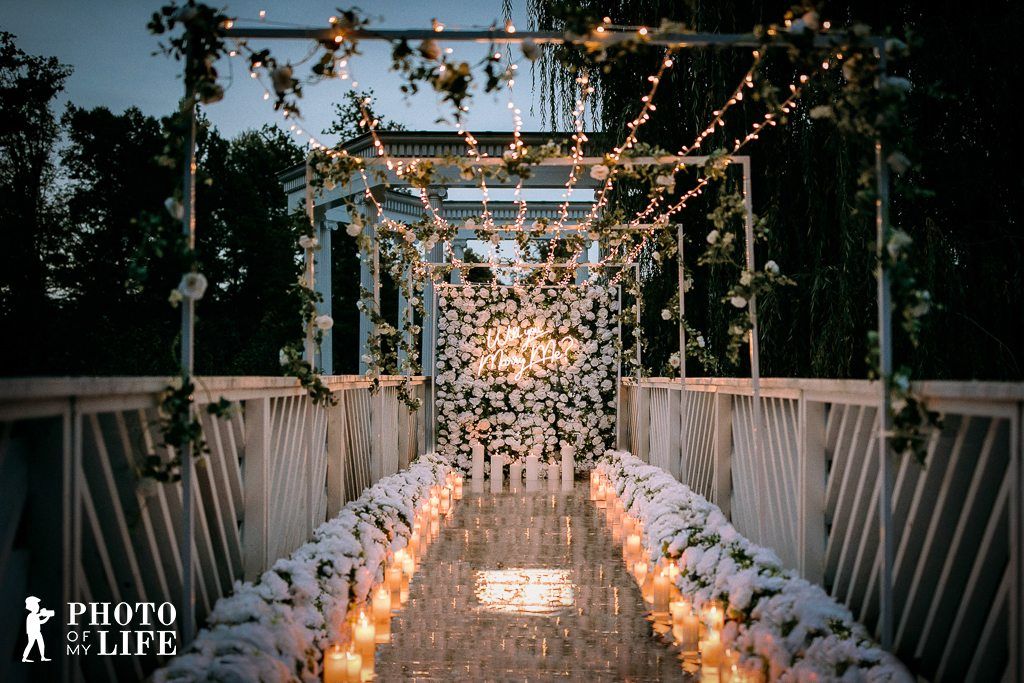 Shine Bright proposal on bridge – fairy lights tunnel with flower wall and candle path