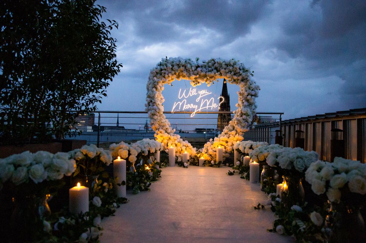 Marriage proposal in Cologne – cathedral rooftop with white flower heart at night