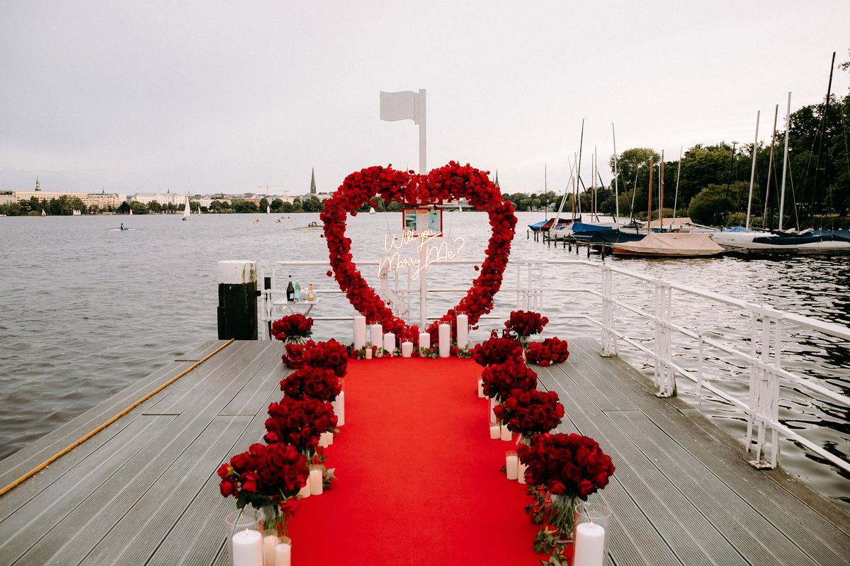 Marriage proposal in Hamburg – Alster lake jetty with red heart and red roses in daytime