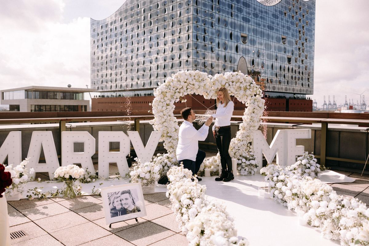 Marriage proposal in Hamburg – Elbphilharmonie with MARRY ME sign, man kneeling