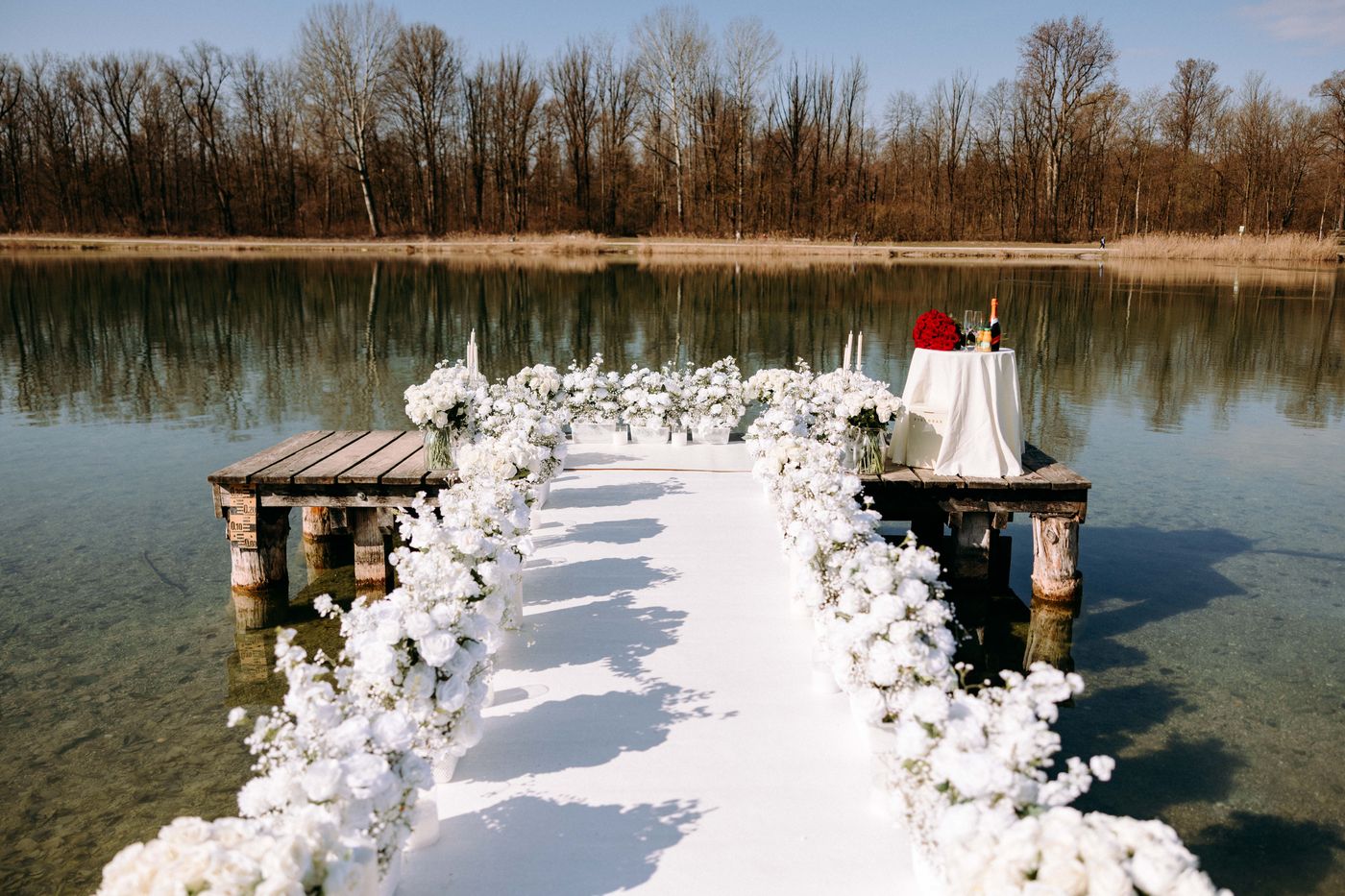 White Blossom proposal on lake jetty – couple surrounded by a sea of white flowers