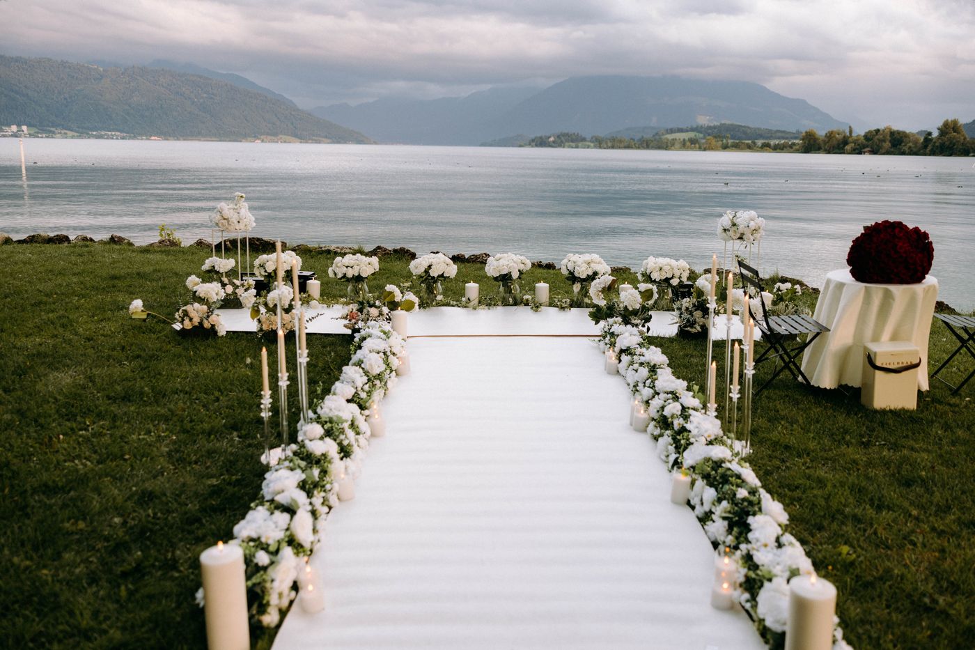 White Blossom proposal at mountain lake – white flower aisle with candles and mountain view